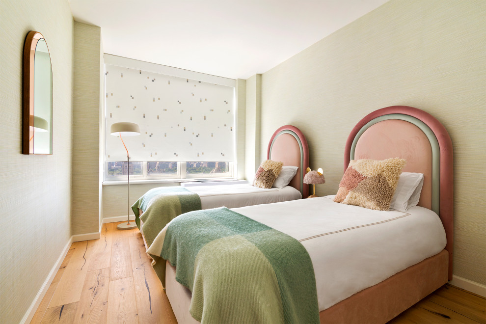 Photo of a contemporary kids' bedroom for girls in New York with green walls, medium hardwood floors and brown floor.