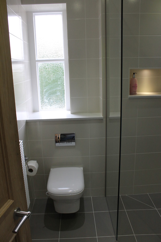 Photo of a small contemporary bathroom with a wall-mounted sink, a wall mounted toilet, grey tiles and porcelain tiles.