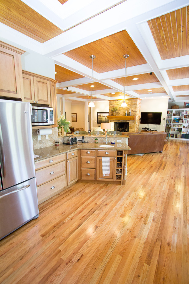 This is an example of a large traditional open plan kitchen in Atlanta with raised-panel cabinets, light wood cabinets, stainless steel appliances and light hardwood floors.