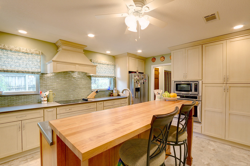 Large elegant eat-in kitchen photo in Miami with white cabinets, green backsplash, stainless steel appliances, an island, a double-bowl sink and recessed-panel cabinets