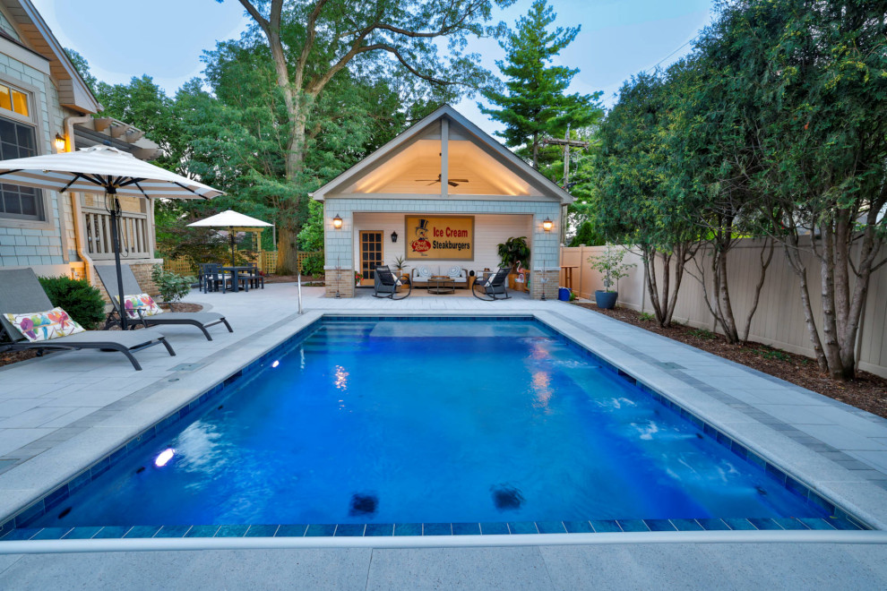 Pool house - small traditional backyard stone and rectangular pool house idea in Chicago