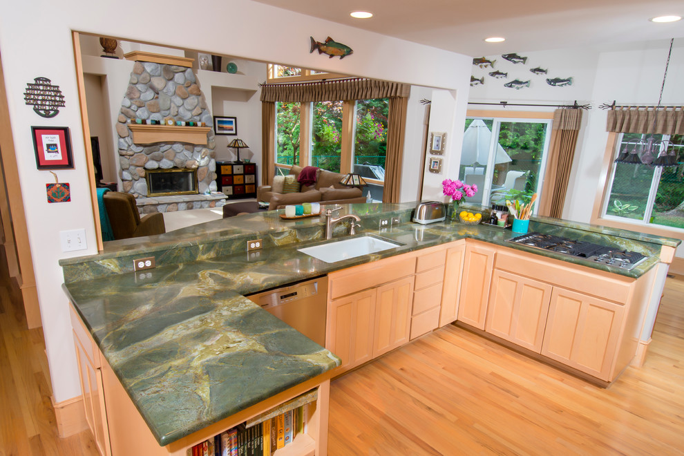 Large transitional u-shaped open plan kitchen in Seattle with an undermount sink, shaker cabinets, light wood cabinets, granite benchtops, stainless steel appliances, light hardwood floors, a peninsula, beige floor and green benchtop.