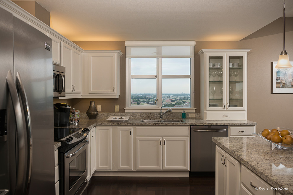 Inspiration for a transitional dark wood floor open concept kitchen remodel in Dallas with an undermount sink, flat-panel cabinets, beige cabinets, granite countertops, stainless steel appliances and an island