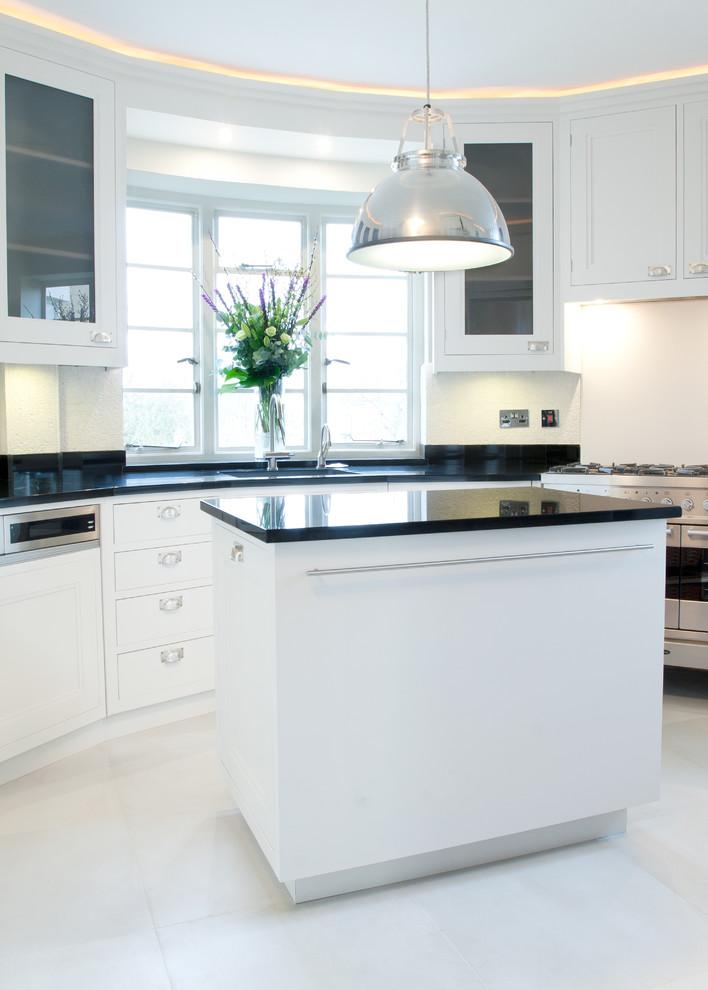 Photo of a mid-sized traditional u-shaped separate kitchen in London with an undermount sink, quartz benchtops, limestone floors and with island.