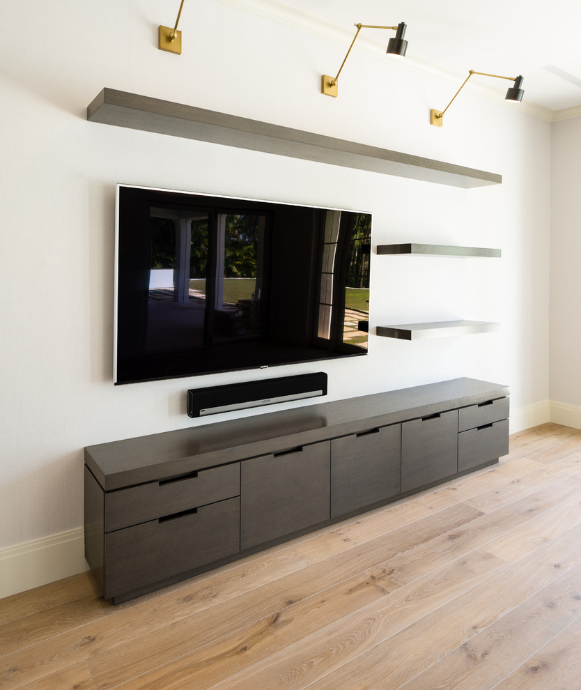 This is an example of a large contemporary formal open concept living room in Miami with white walls, medium hardwood floors and a built-in media wall.