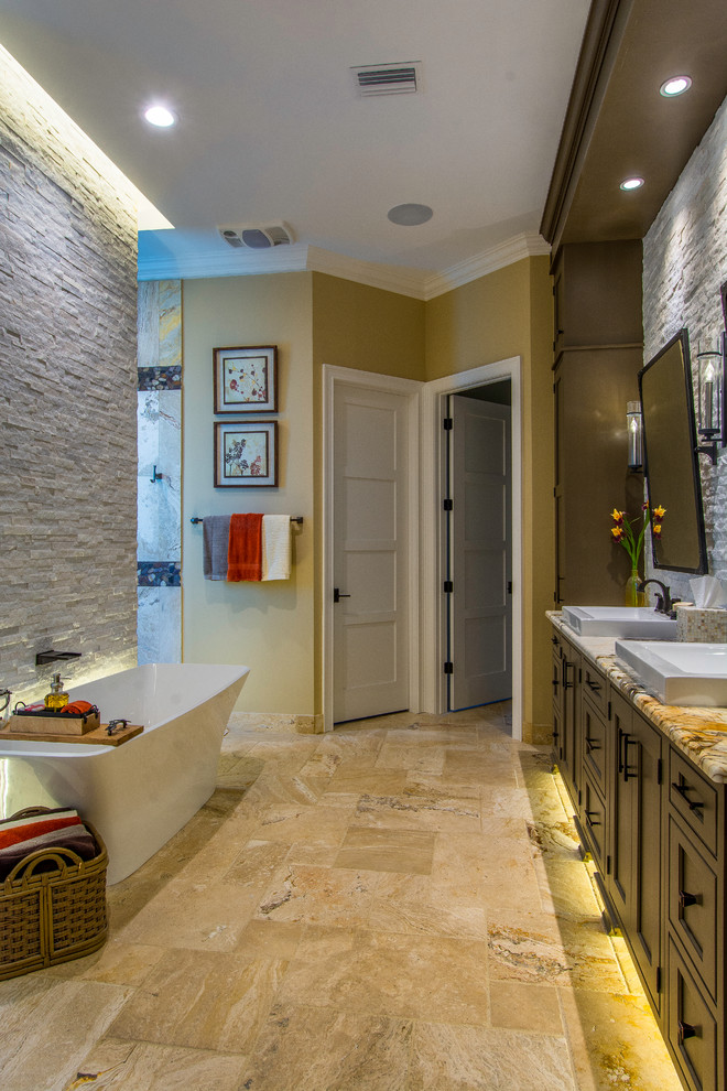 Photo of a large arts and crafts master bathroom in Tampa with beaded inset cabinets, green cabinets, a freestanding tub, a double shower, a one-piece toilet, white tile, stone tile, brown walls, travertine floors, a vessel sink, quartzite benchtops, multi-coloured floor and an open shower.