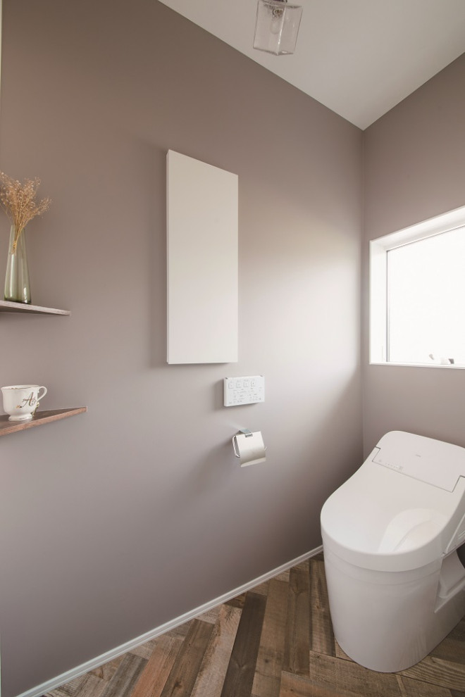 Exemple d'un WC et toilettes scandinave avec un mur beige et un sol marron.