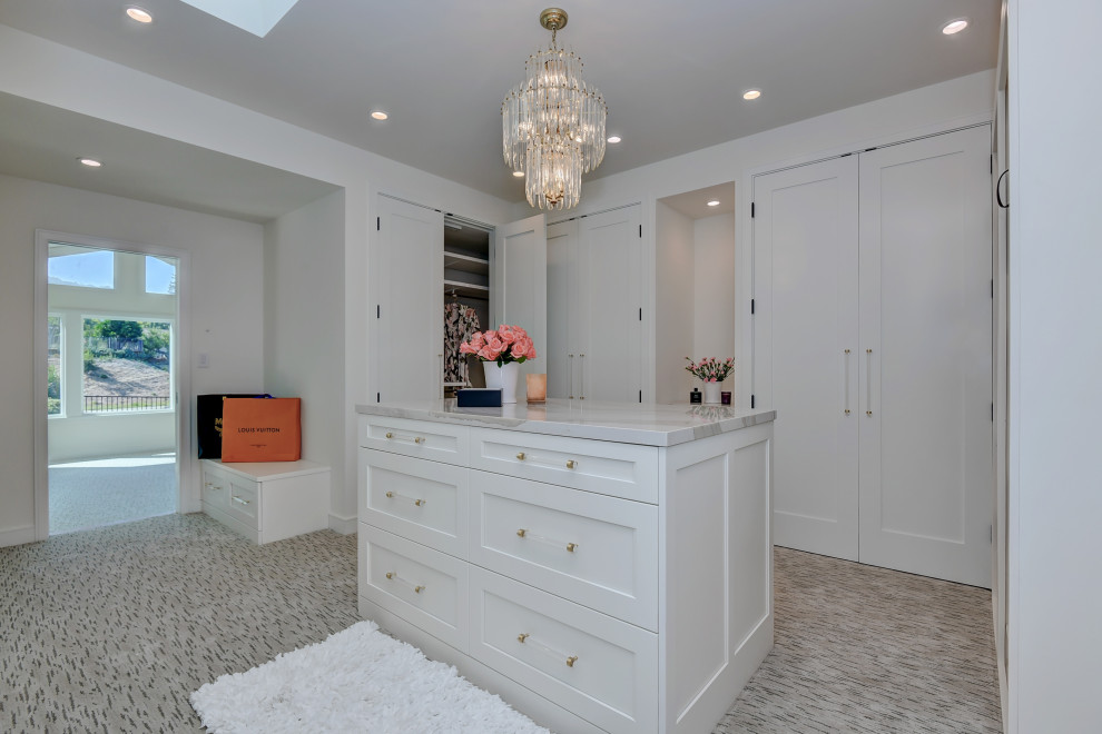 This is an example of an expansive contemporary gender-neutral walk-in wardrobe in San Francisco with shaker cabinets, white cabinets, carpet and multi-coloured floor.