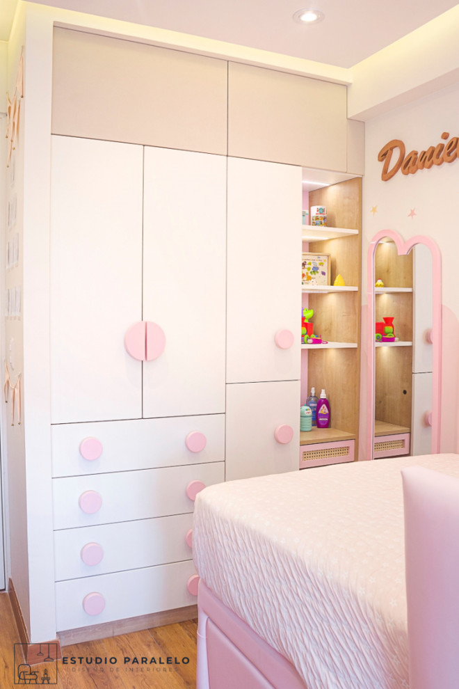 Inspiration for a small eclectic children’s room for girls with white walls, laminate floors, brown floors, a drop ceiling and brick walls.