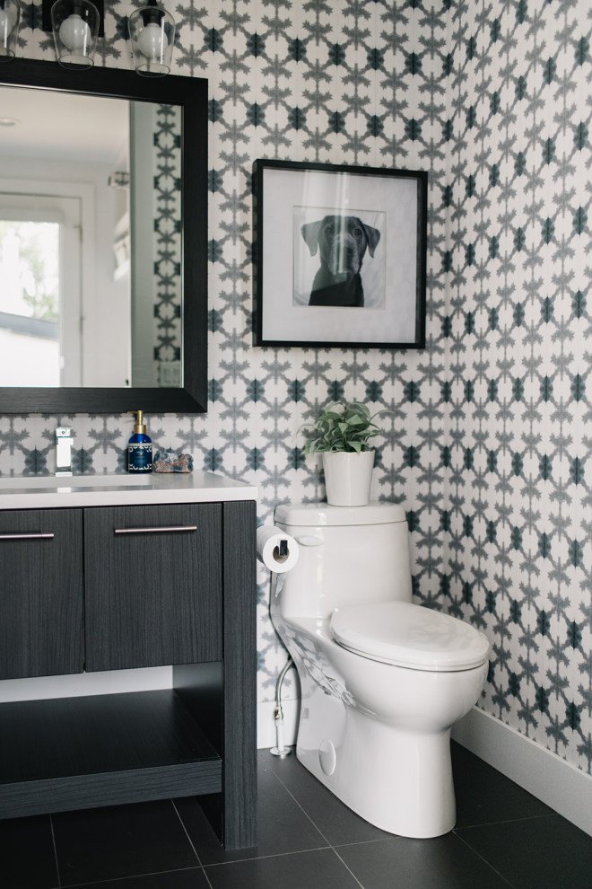 Inspiration for a transitional powder room in Edmonton with flat-panel cabinets, black cabinets, multi-coloured walls, an undermount sink, black floor and white benchtops.