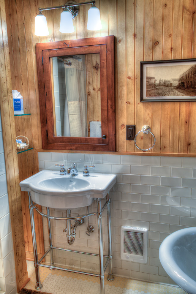 Claw-foot bathtub - mid-sized rustic master gray tile and ceramic tile ceramic tile claw-foot bathtub idea with a pedestal sink, flat-panel cabinets and medium tone wood cabinets