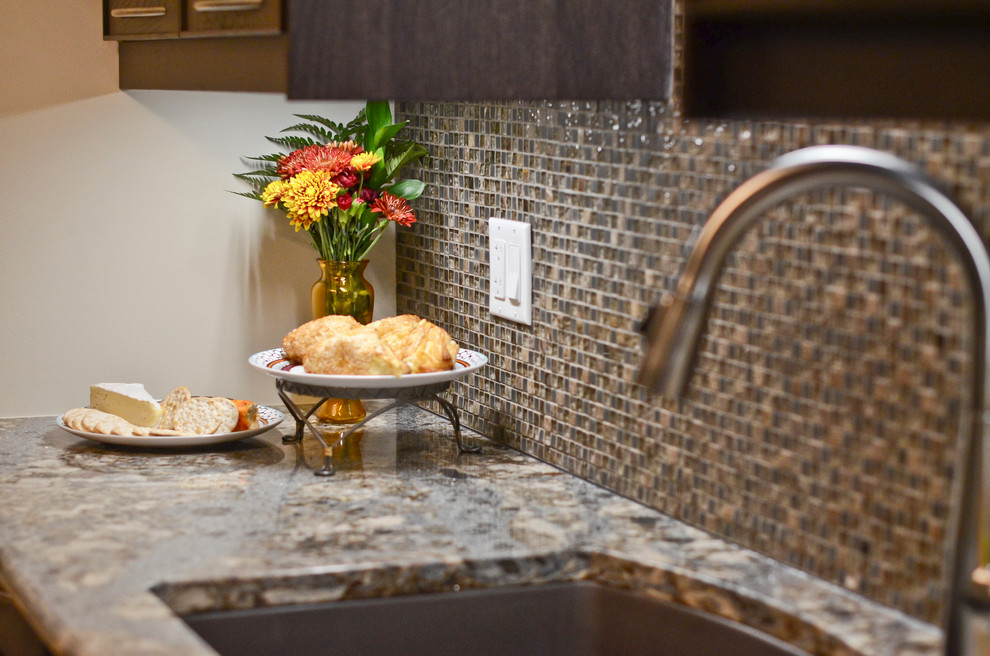 Mid-sized transitional galley porcelain tile home design photo in Ottawa with an undermount sink, glass-front cabinets, brown cabinets, quartz countertops, brown backsplash, glass sheet backsplash and stainless steel appliances