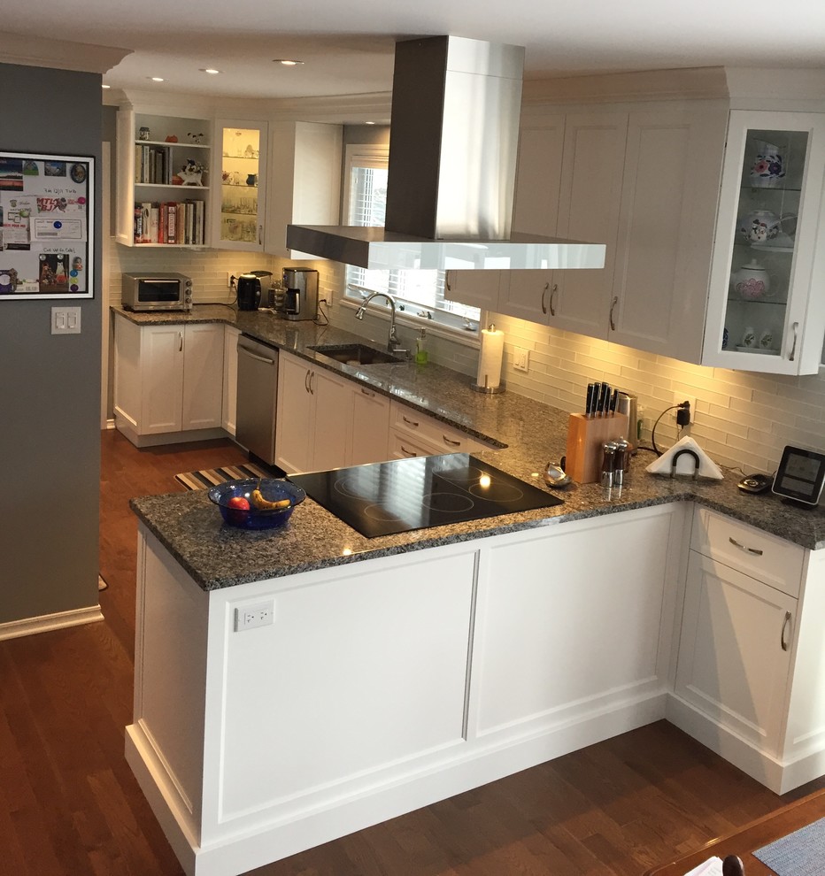 Inspiration for a mid-sized transitional single-wall dark wood floor and brown floor eat-in kitchen remodel in Montreal with an undermount sink, recessed-panel cabinets, white cabinets, quartz countertops, white backsplash, glass tile backsplash, white appliances and a peninsula