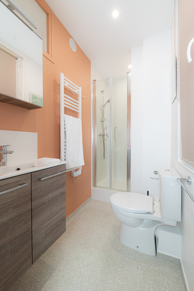Пример оригинального дизайна: маленькая ванная комната в классическом стиле с плоскими фасадами, коричневыми фасадами, душем в нише, унитазом-моноблоком, белой плиткой, керамической плиткой, оранжевыми стенами, полом из терраццо, душевой кабиной, врезной раковиной, бежевым полом, тумбой под одну раковину, подвесной тумбой, душем с распашными дверями и белой столешницей для на участке и в саду