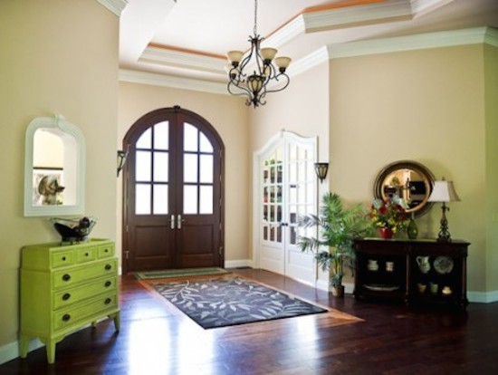 Large medium tone wood floor entry hall photo with a dark wood front door