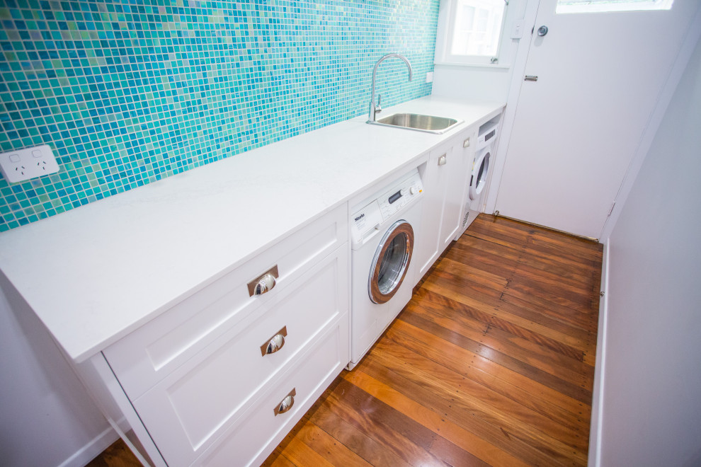 Photo of a mid-sized beach style single-wall dedicated laundry room in Brisbane.