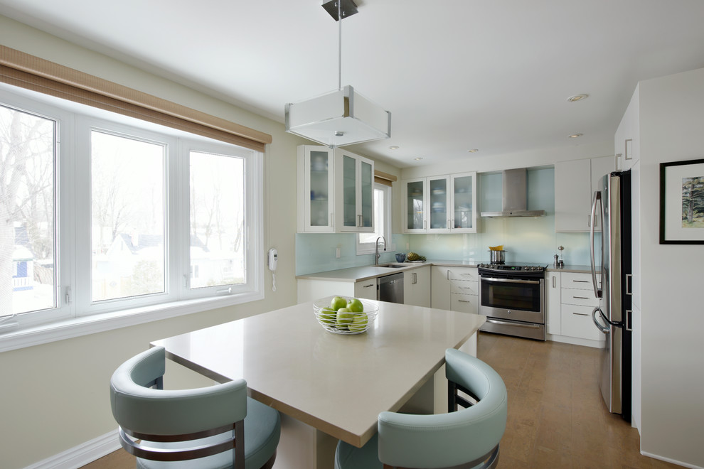Example of a mid-sized transitional u-shaped cork floor enclosed kitchen design in Ottawa with an undermount sink, flat-panel cabinets, white cabinets, quartz countertops, blue backsplash, glass sheet backsplash, stainless steel appliances and an island