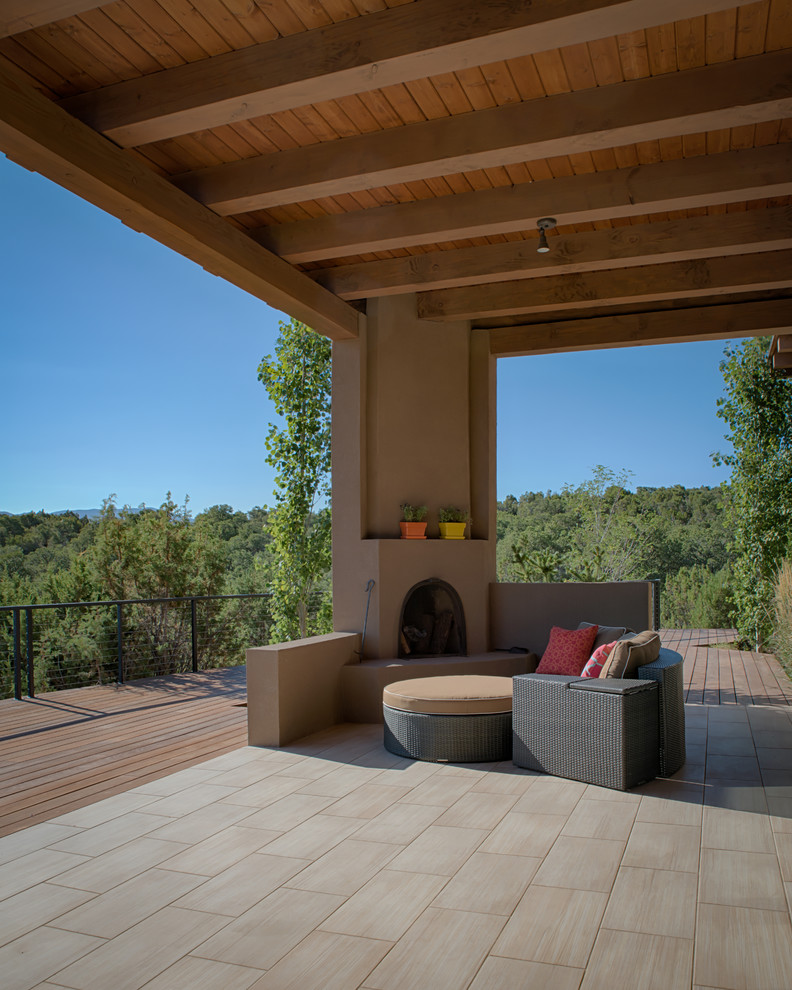 Design ideas for an expansive contemporary backyard deck in Albuquerque with a roof extension.