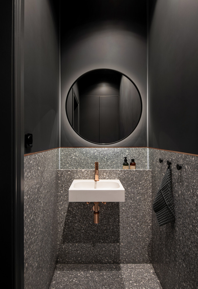 Exemple d'un petit WC et toilettes avec un carrelage gris, des carreaux de béton, un mur gris, un sol en terrazzo, un lavabo suspendu et un sol gris.