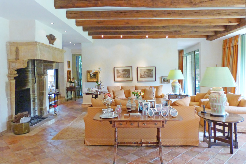 Geräumiges, Offenes Modernes Wohnzimmer mit weißer Wandfarbe, Terrakottaboden, Kamin und Kaminumrandung aus Stein in Düsseldorf