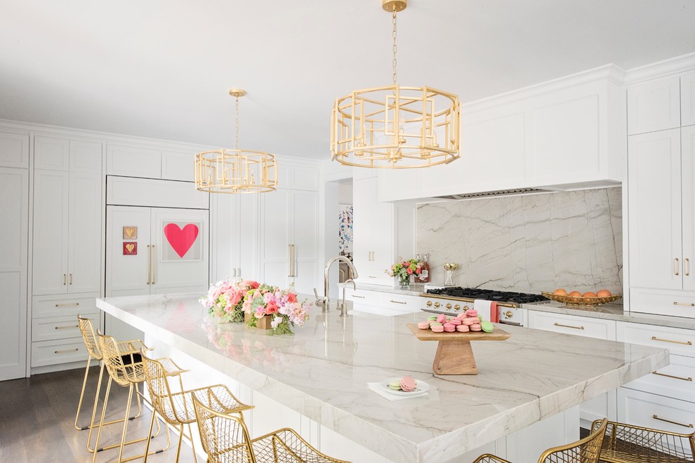 Example of a large transitional l-shaped medium tone wood floor and brown floor open concept kitchen design with a farmhouse sink, recessed-panel cabinets, white cabinets, quartzite countertops, white backsplash, stone slab backsplash, paneled appliances and an island