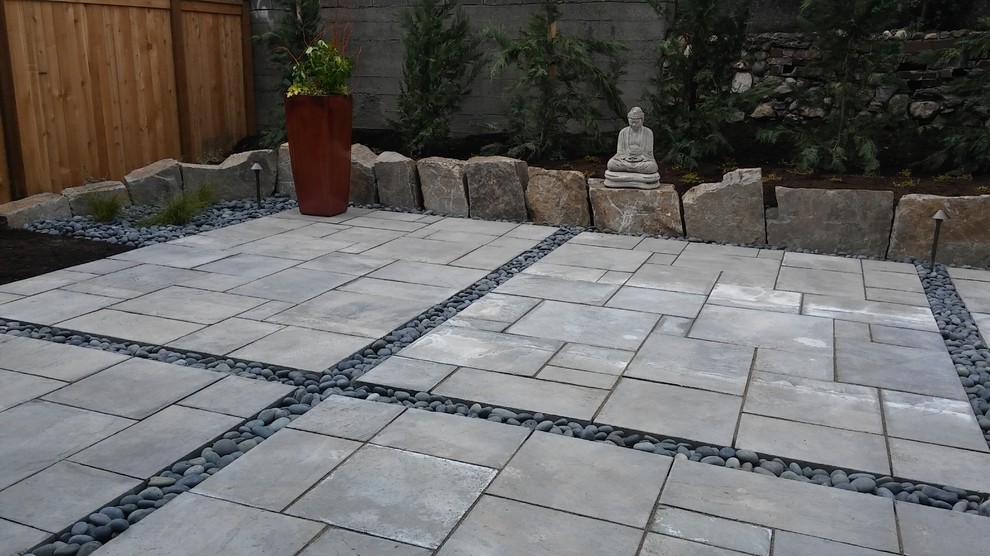 This is an example of a mid-sized contemporary backyard patio in Seattle with concrete pavers and no cover.