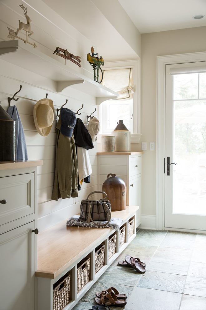 Beach style mudroom in Boston with beige walls.