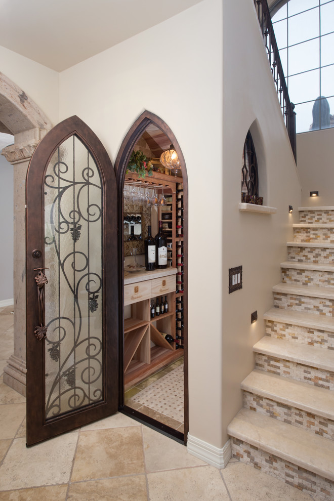 Design ideas for a mid-sized mediterranean wine cellar in Phoenix with travertine floors and storage racks.