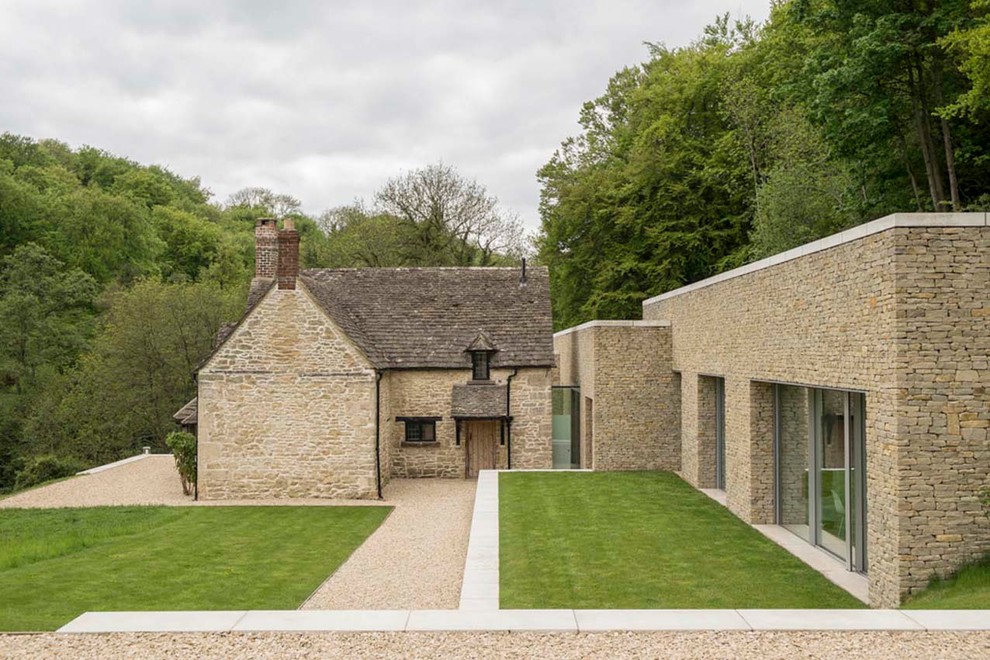 This is an example of a country one-storey beige exterior in London with stone veneer.