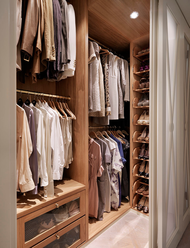 Design ideas for a large traditional women's walk-in wardrobe in London with open cabinets, light wood cabinets and carpet.