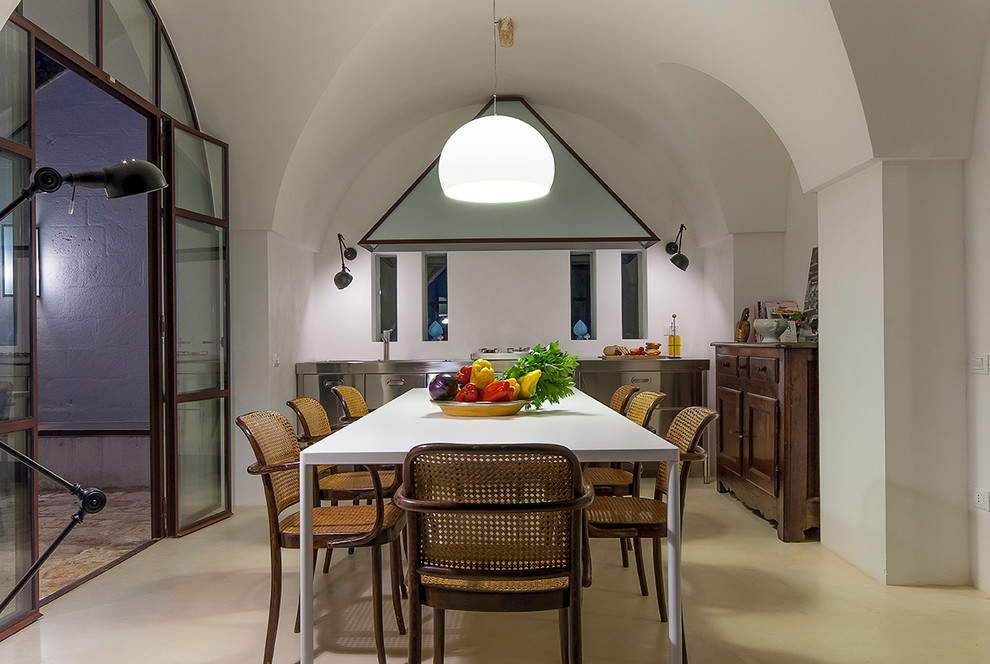 This is an example of a mid-sized mediterranean kitchen/dining combo in Bari with white walls.