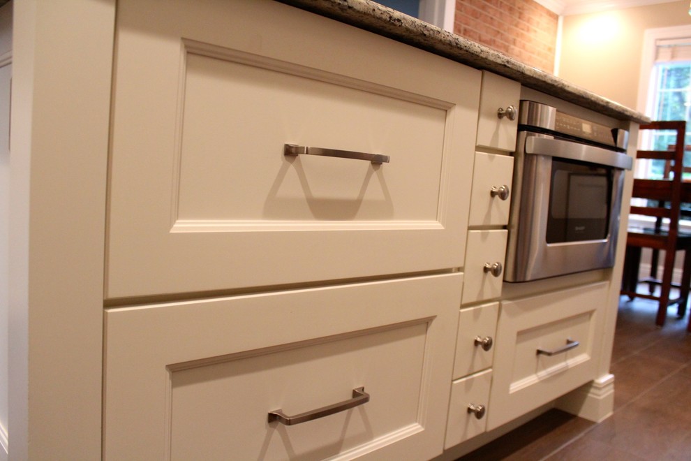 Eat-in kitchen - mid-sized transitional u-shaped porcelain tile and brown floor eat-in kitchen idea in DC Metro with an undermount sink, recessed-panel cabinets, white cabinets, granite countertops, beige backsplash, porcelain backsplash, stainless steel appliances and an island