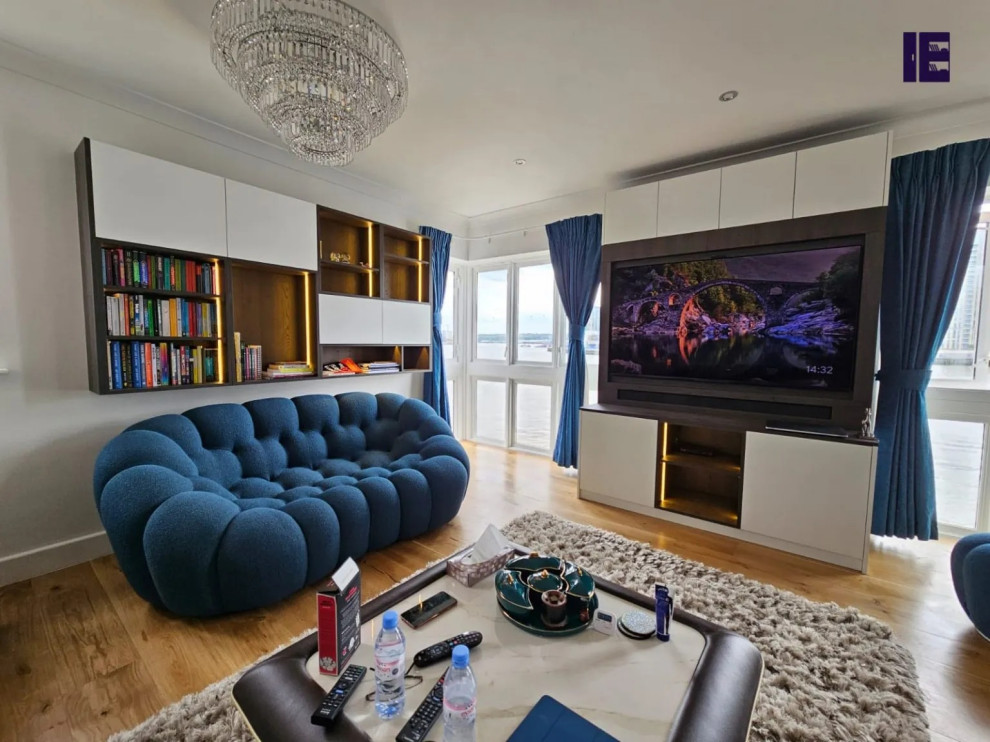 Inspiration for a large modern open concept family room in London with a built-in media wall.