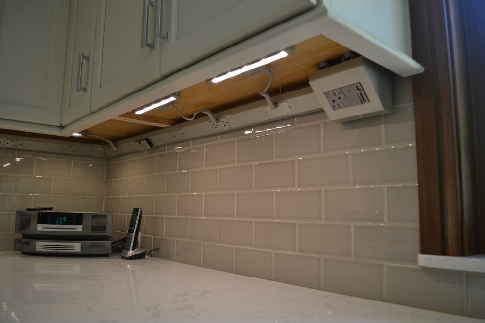 Kitchen - large transitional ceramic tile kitchen idea with an undermount sink, recessed-panel cabinets, white cabinets, quartzite countertops, gray backsplash, subway tile backsplash, stainless steel appliances and an island