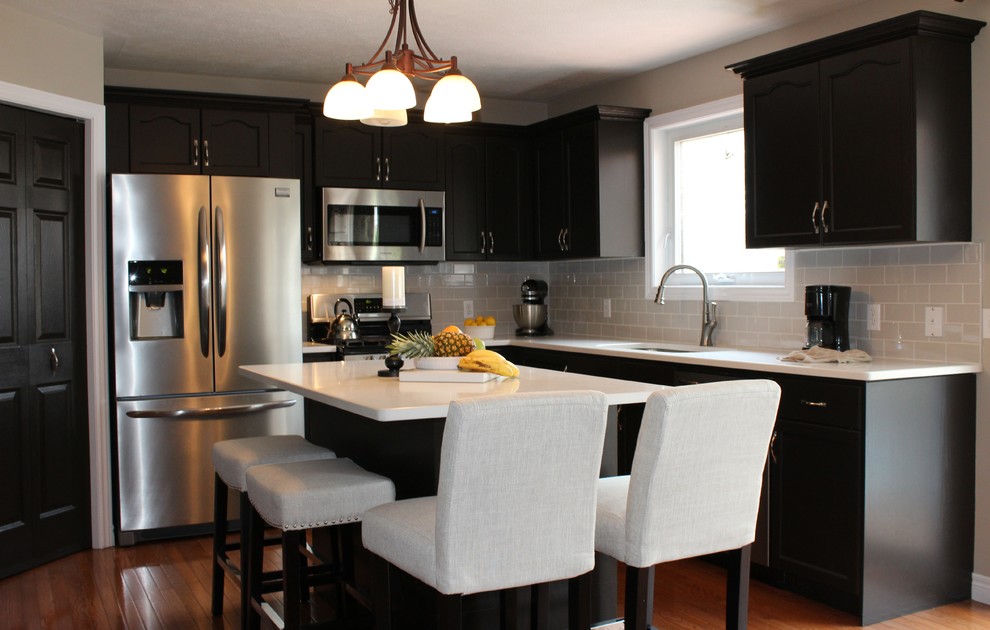 Mid-sized transitional u-shaped medium tone wood floor open concept kitchen photo in Toronto with an undermount sink, recessed-panel cabinets, dark wood cabinets, quartzite countertops, gray backsplash, subway tile backsplash, stainless steel appliances and an island