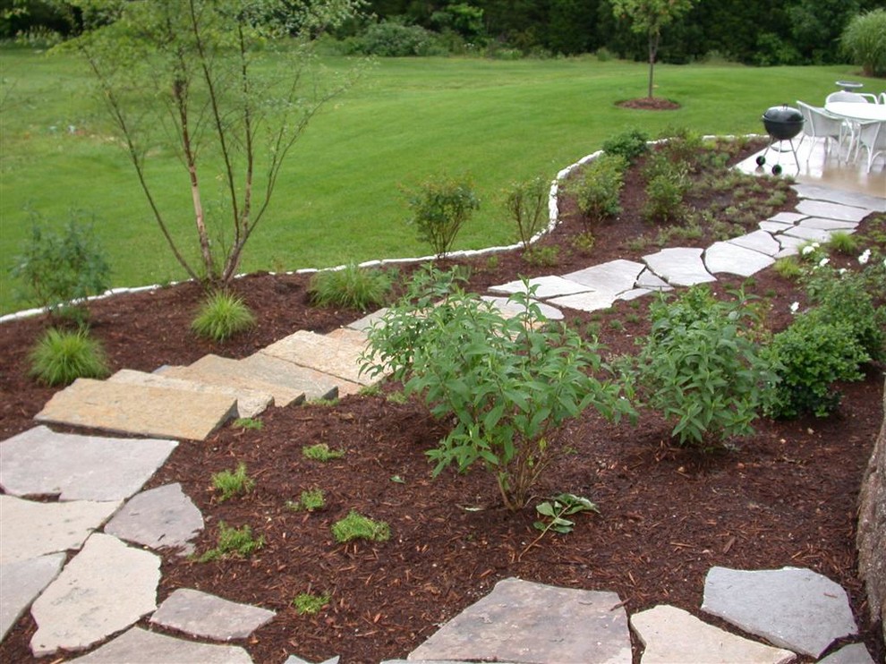 Photo of a traditional side yard shaded formal garden for summer in St Louis with a garden path and natural stone pavers.
