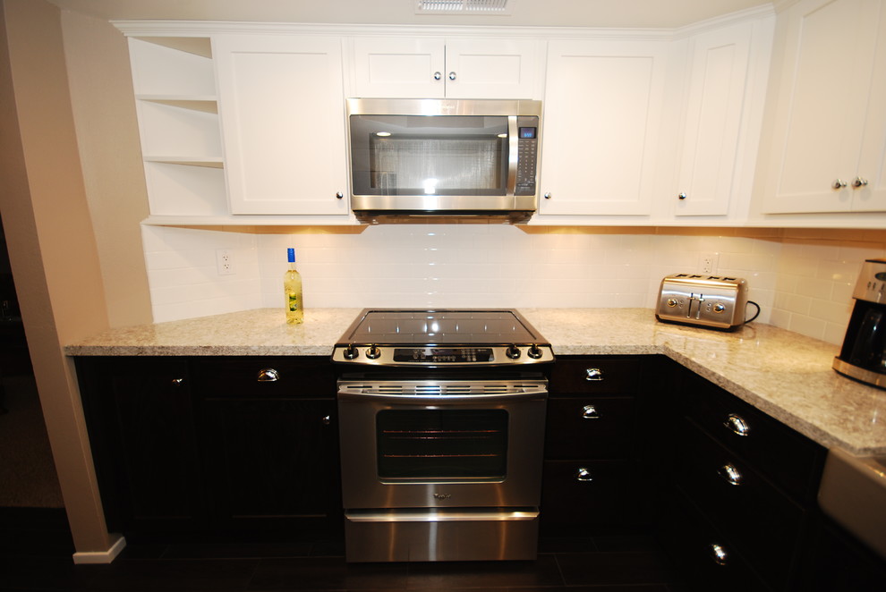 Small transitional u-shaped porcelain tile eat-in kitchen photo with a farmhouse sink, shaker cabinets, white cabinets, quartz countertops, white backsplash, subway tile backsplash, stainless steel appliances and gray walls