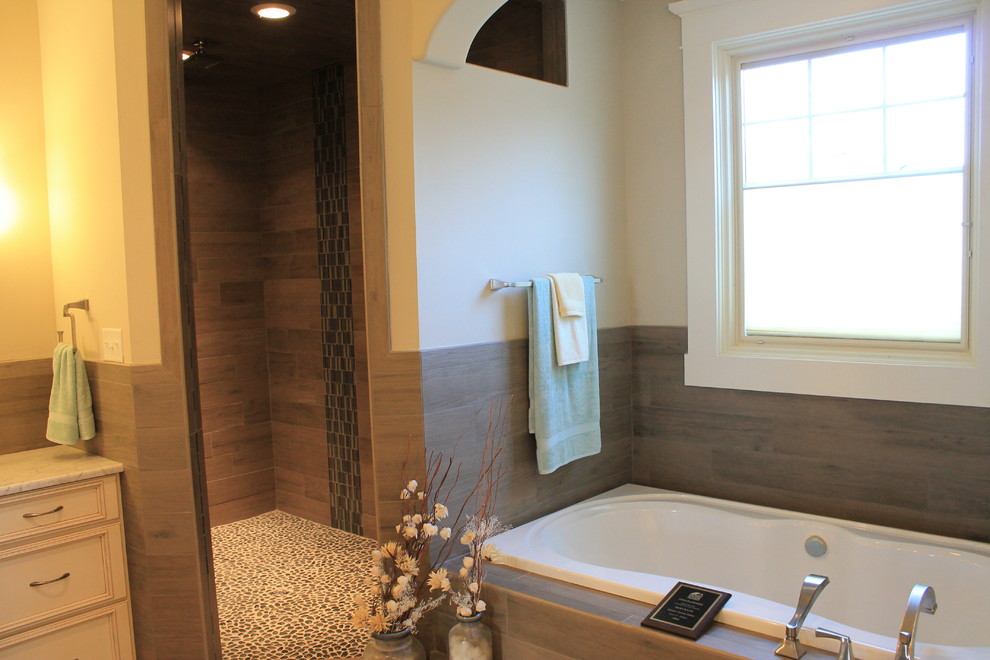 Traditional master bathroom in Richmond with recessed-panel cabinets, white cabinets, a drop-in tub, a corner shower, brown tile, porcelain tile, beige walls and a hinged shower door.