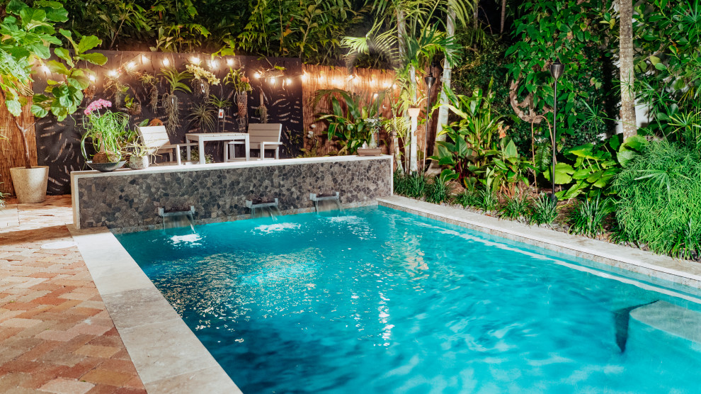 Esempio di una piccola piscina monocorsia etnica rettangolare dietro casa con paesaggistica bordo piscina e pavimentazioni in pietra naturale