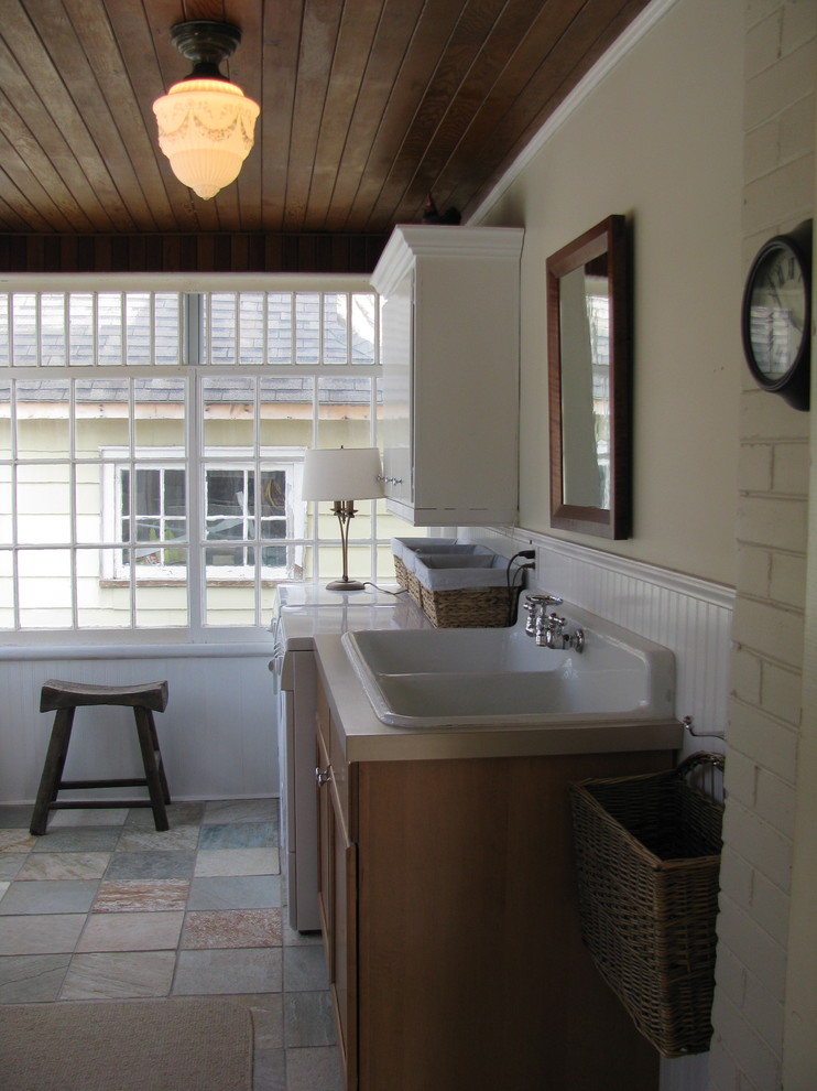 Traditional laundry room in Toronto with a drop-in sink and slate floors.