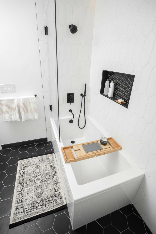Medium sized modern family bathroom in Dallas with freestanding cabinets, medium wood cabinets, a corner bath, a shower/bath combination, black and white tiles, mosaic tiles, white walls, ceramic flooring, a submerged sink, quartz worktops, black floors, a hinged door, white worktops, a wall niche, a single sink and a freestanding vanity unit.