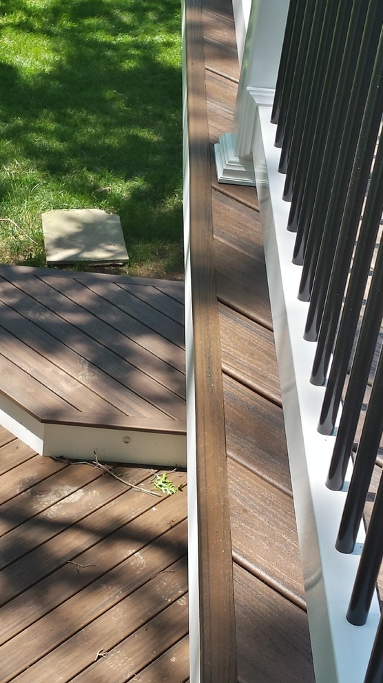 Inspiration for a large modern backyard deck remodel in Baltimore with a roof extension