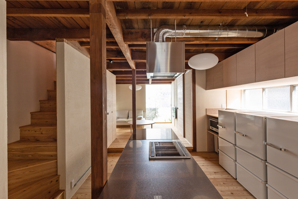 Idéer för ett mellanstort modernt grå linjärt kök med öppen planlösning, med en undermonterad diskho, luckor med profilerade fronter, skåp i ljust trä, bänkskiva i rostfritt stål, stänkskydd med metallisk yta, rostfria vitvaror, ljust trägolv, en köksö och beiget golv