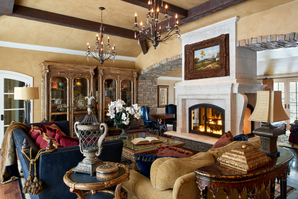 Large mediterranean open concept family room in Denver with beige walls, a two-sided fireplace, a stone fireplace surround and medium hardwood floors.