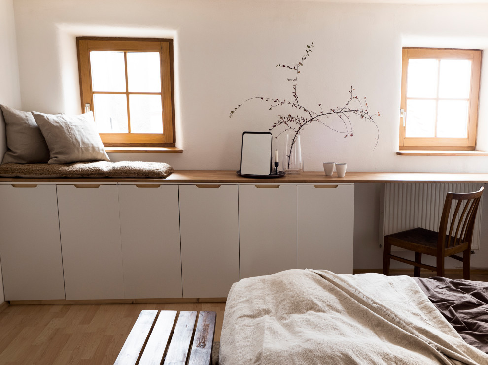 Mittelgroßes Eklektisches Hauptschlafzimmer mit weißer Wandfarbe, Laminat, braunem Boden und Tapetenwänden in München