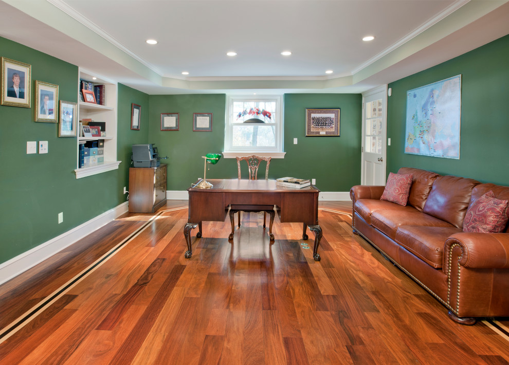 This is an example of a mid-sized transitional home office in Philadelphia with green walls, medium hardwood floors, no fireplace, a freestanding desk and brown floor.