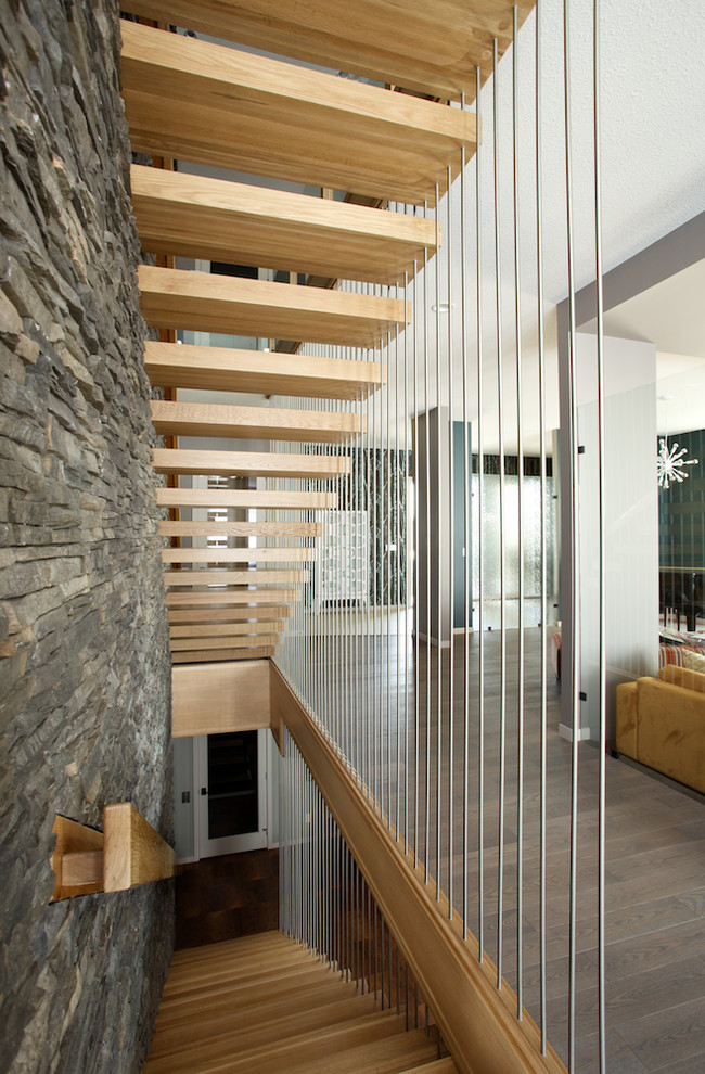 This is an example of a modern wood floating staircase in Edmonton with open risers and mixed railing.
