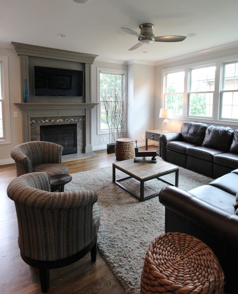 This is an example of a mid-sized transitional open concept family room in Other with white walls, dark hardwood floors, a standard fireplace, a tile fireplace surround and a wall-mounted tv.