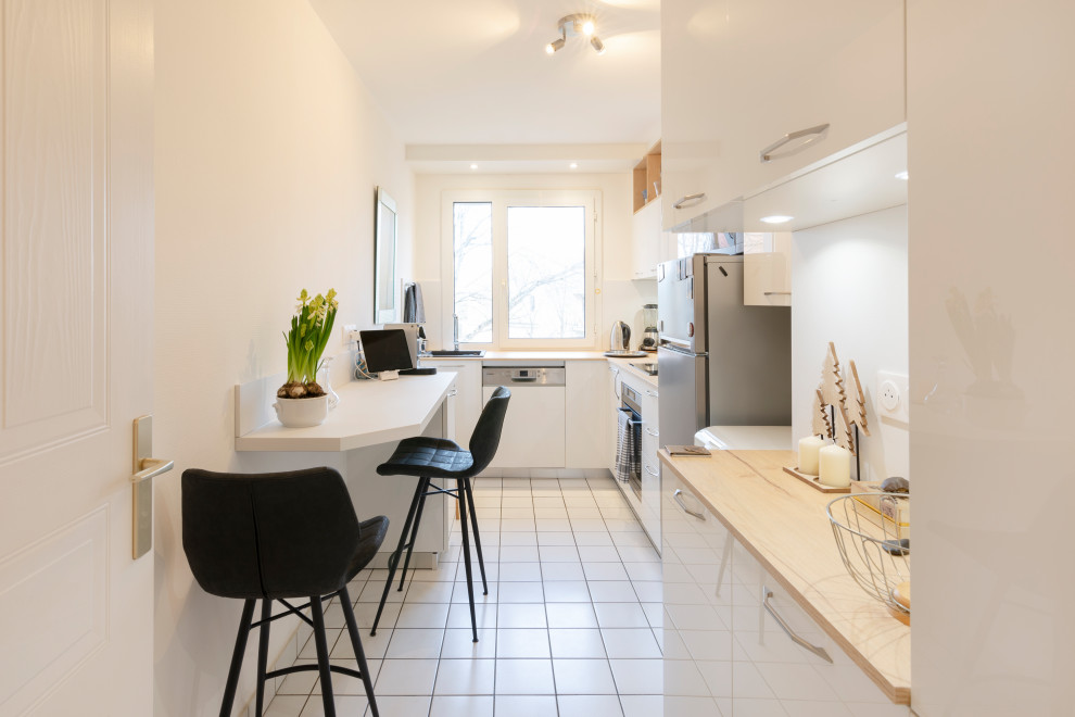Immagine di una piccola cucina a L design chiusa con ante bianche, top in laminato, paraspruzzi bianco e penisola