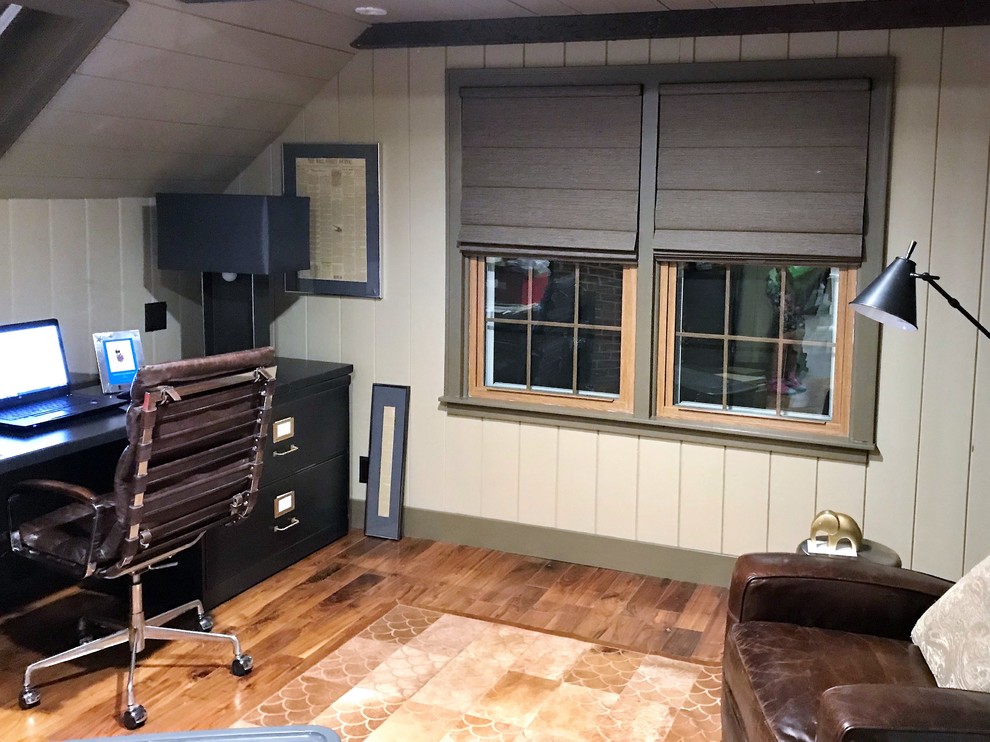 This is an example of a mid-sized arts and crafts study room in Chicago with beige walls, medium hardwood floors, no fireplace, a freestanding desk and brown floor.